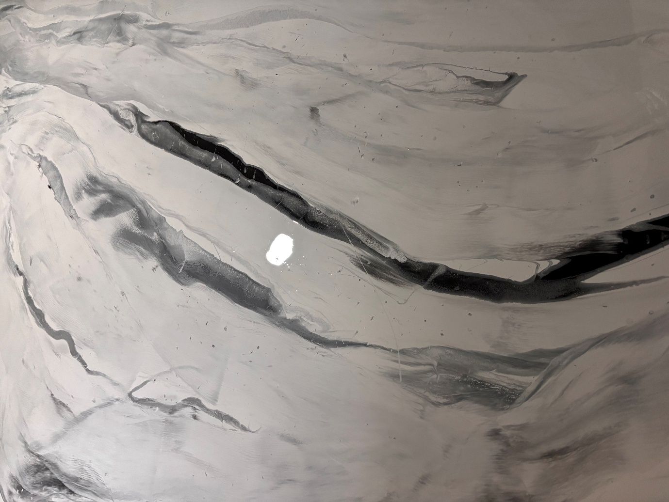Close detail of hand-poured pearl and charcoal metallic epoxy veining