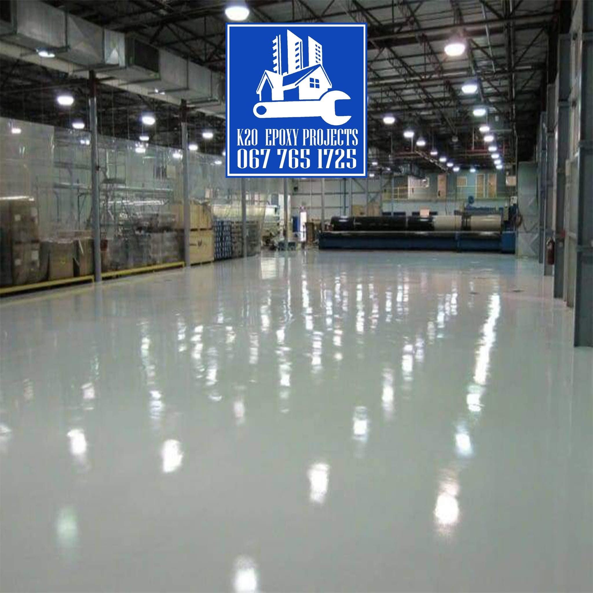 High-gloss industrial epoxy floor running the length of a warehouse