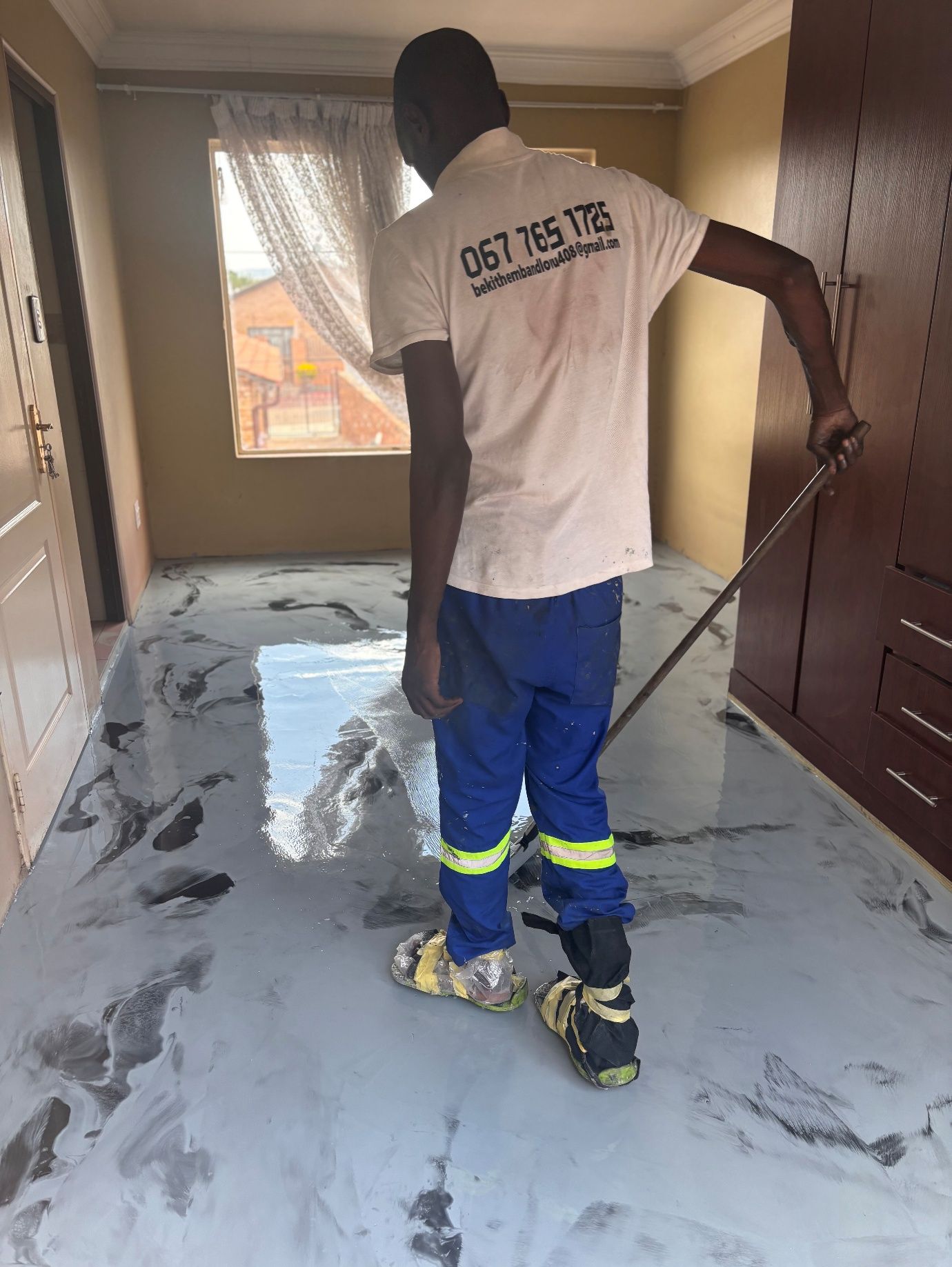 K20 installer spreading metallic epoxy across a residential floor